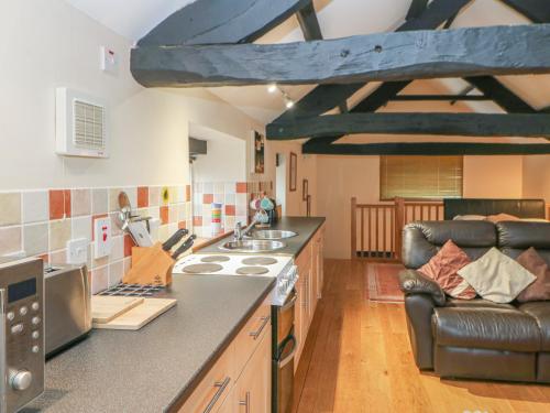 a kitchen with a stove and a couch in a room at The Annex - Eden House in Edenhall