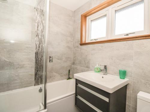 a bathroom with a sink and a shower at Isla Cottage in Rattray