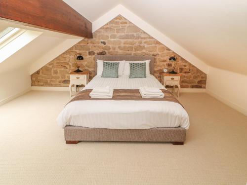 a bedroom with a large bed in a attic at The Tack Room Cottage in Ashover