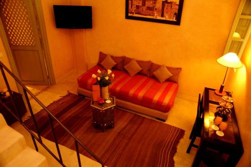 a living room with a red couch and a table at Riad Shama Suites & Spa in Marrakech