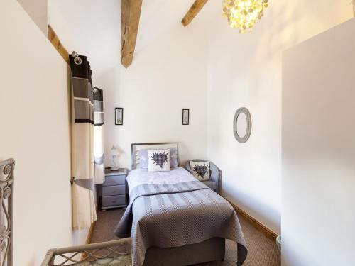 um quarto com uma cama num quarto com paredes brancas em Little Cow House em Chirk