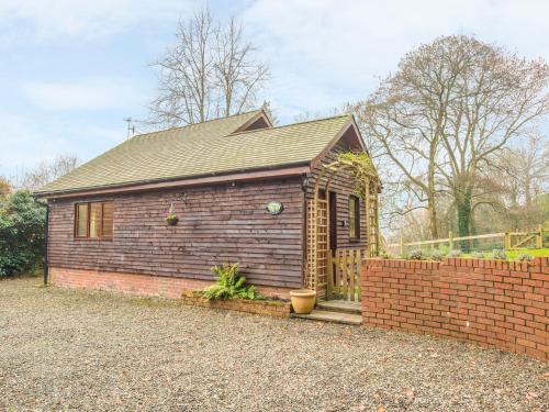 a small brick house with a brick wall at Woodpeckers Cottage in Church Stretton
