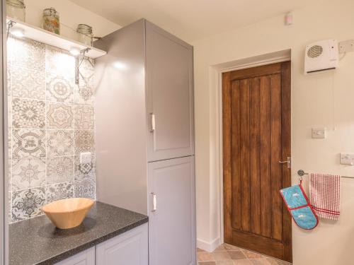 a bathroom with a sink and a wooden door at Woodpeckers Cottage in Church Stretton