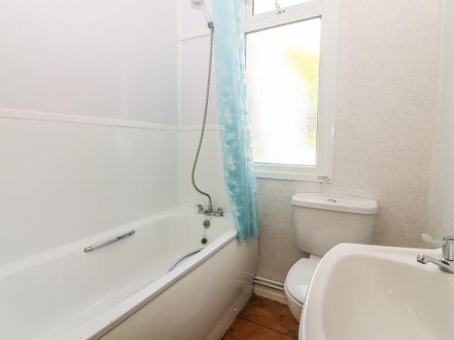 a bathroom with a tub and a toilet and a sink at Highdown in Bigbury on Sea