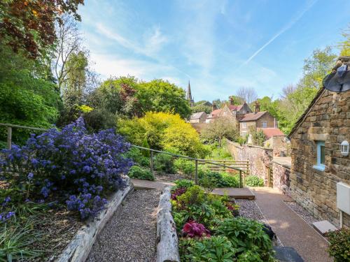 a garden with purple and purple flowers next to a building at Vale Barn in Dronfield