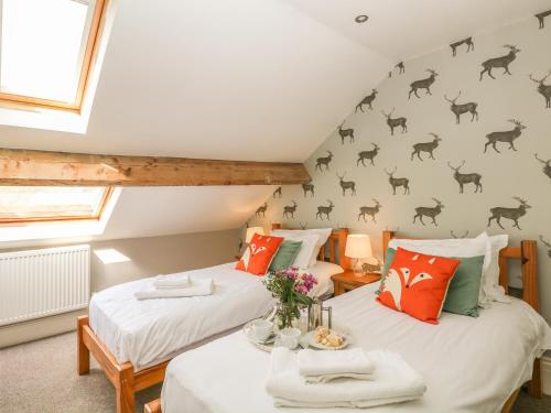 two beds in a attic room with deer on the wall at Talbot House in Castleton