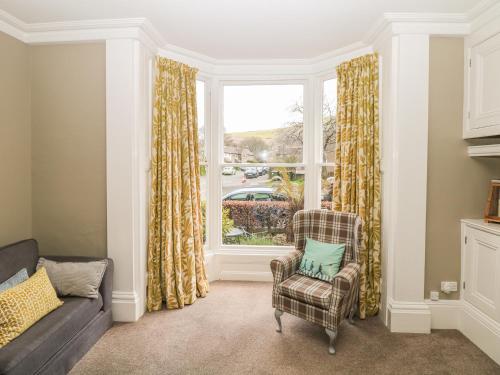 a living room with a couch and a window at Talbot House in Castleton