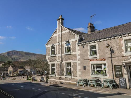a building with tables and chairs on a street at Talbot House in Castleton