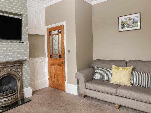 a living room with a couch and a television at Talbot House in Castleton