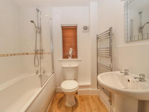 Un baño blanco con inodoro y lavabo. en 6 Malthouse Court, en Saint Decumans