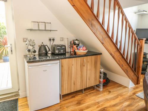 a kitchen with a dishwasher and a staircase at End Retreat in Ashmanhaugh