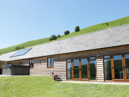a log cabin with a grass roof at 2 Beacon View Barn in Felindre