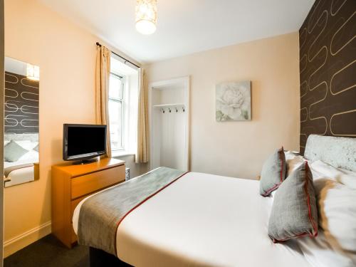 sypialnia z łóżkiem i telewizorem z płaskim ekranem w obiekcie OYO Braeriach Hotel, Highlands Scotland w mieście Newtonmore