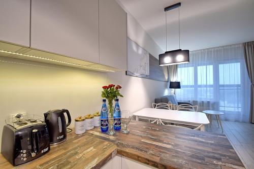 a kitchen with a counter with vases of flowers on it at Apartamenty Onyx SeaView by Rent like home in Międzyzdroje