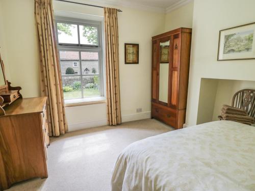 a bedroom with a bed and a large window at The Conifers in Hutton Magna
