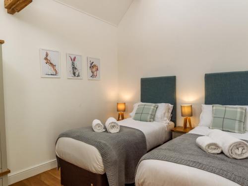 a bedroom with two beds with towels on them at Oxen Cottage Nables Farm in Seagry