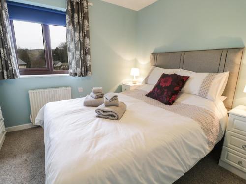 a bedroom with a large white bed with towels on it at Ardwyn in Bala