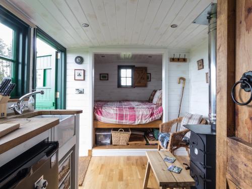 a tiny house with a bed in a room at Peat Gate Shepherd's Hut in Greenhead
