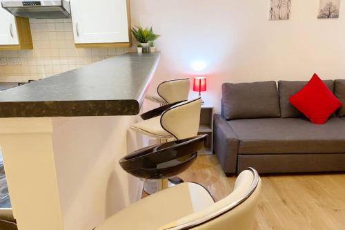 a kitchen and living room with a counter and a couch at Cozy Nights - Ibrox Street in Glasgow