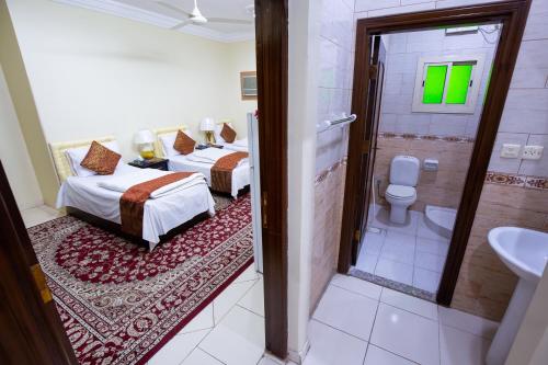 two beds in a room with a shower and a toilet at Al Eairy Apartments - Makkah 8 in Mecca
