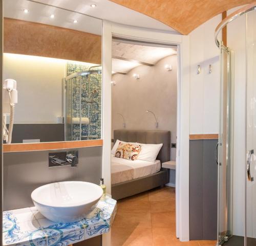 ein Bad mit einem Waschbecken und einem Bett in der Unterkunft Casa Turrisi in Taormina