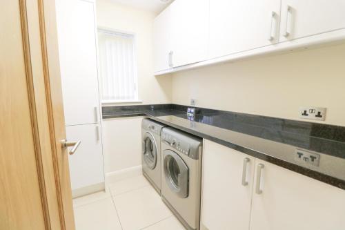a laundry room with a washer and dryer in it at Arnant in Barmouth
