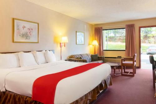 a hotel room with a large bed and a desk at Days Inn by Wyndham Adairsville in Adairsville