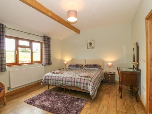 a bedroom with a bed and a desk and a window at Caer Moel in Llanwnda
