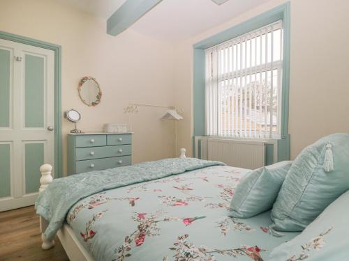 una camera con un letto, un comò e una finestra di Worth Valley Cottage a Haworth