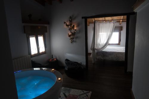 a bathroom with a tub and a bedroom with a bed at La Morada del Druida in Los Narros
