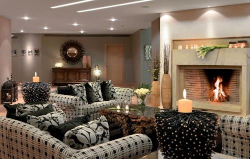 a living room with couches and a fireplace at Divani Meteora Hotel in Kalabaka