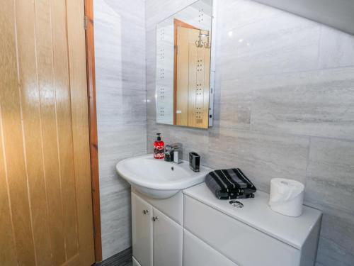 a white bathroom with a sink and a mirror at Fortunatus in Whitby