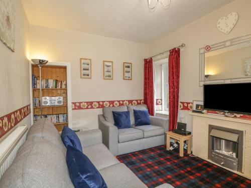a living room with a couch and a fireplace at Fishermans Rest in Burghead