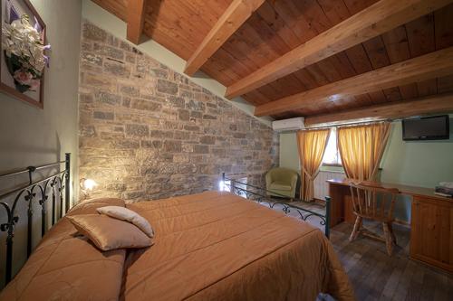 een slaapkamer met een groot bed en een bakstenen muur bij Agriturismo La Ginestra in Cercemaggiore