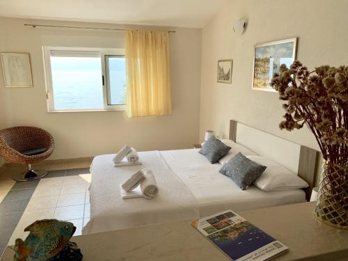 a bedroom with a bed and a table and a window at Villa Orca in Podaca