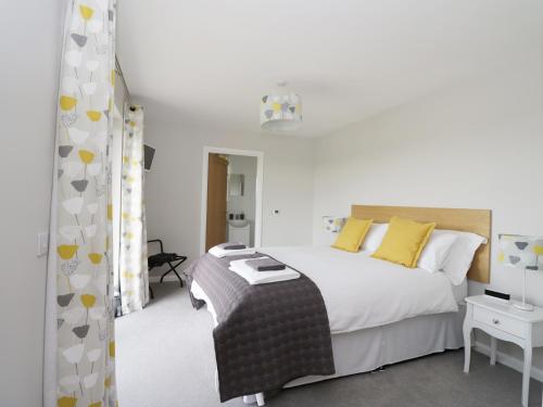 a bedroom with a large white bed and yellow pillows at Chance Inn Lodge in Balmedie