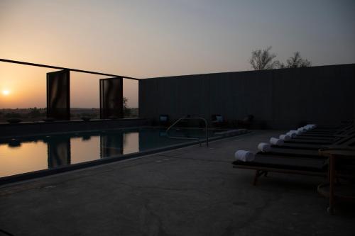 a swimming pool with a sunset in the background at Mysk Al Faya Retreat in Sharjah