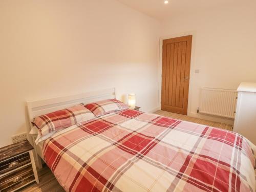 - une chambre avec un lit et une couverture tressée dans l'établissement Cefn Bryn Mawr, à Criccieth