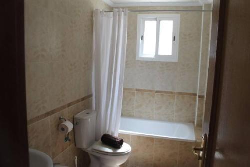łazienka z toaletą, wanną i oknem w obiekcie La Ciñuelica R15 1st Floor Apartment Com Pool L164 w mieście Orihuela