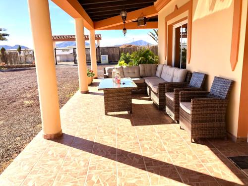 a patio with a couch and chairs and a table at Villa Oliva Fuerteventura in Tuineje