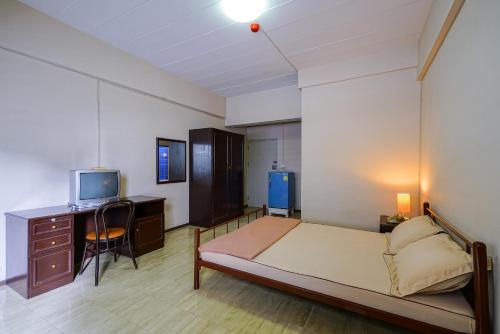una camera con letto, scrivania e TV di Vintage Studio Apartment Thonglor Ekkamai a Ban Na Song