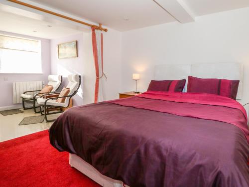 a bedroom with a large bed and a red rug at 5 Firle Road Annexe in Lancing