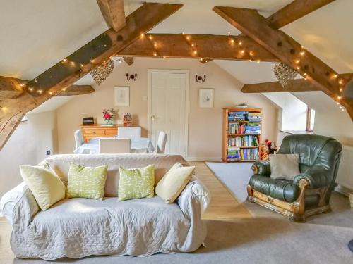 a living room with a couch and a bedroom at Hen Ysgubor Cottage in Bala