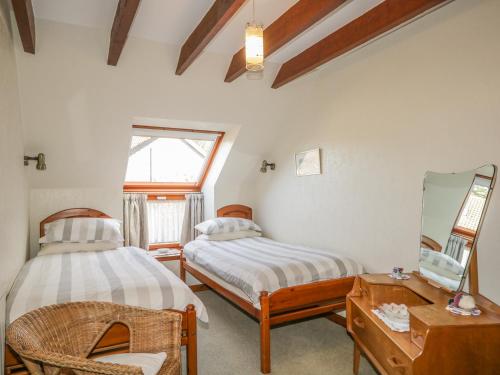 a bedroom with two beds and a mirror at The Farm Steading in Aberlour