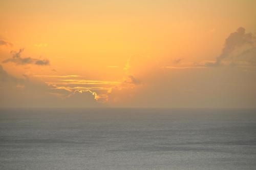 a sunset over the ocean with clouds in the sky at Mango Island Lodges in Saint Joseph