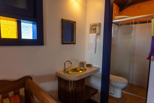 a bathroom with a sink and a toilet at Pousada DiMari in Boicucanga