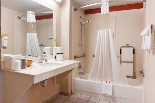 a white bathroom with a sink and a shower at Days Inn by Wyndham Adairsville in Adairsville