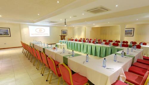 a meeting room with long tables and red chairs at Sovereign Hotel in Kisumu