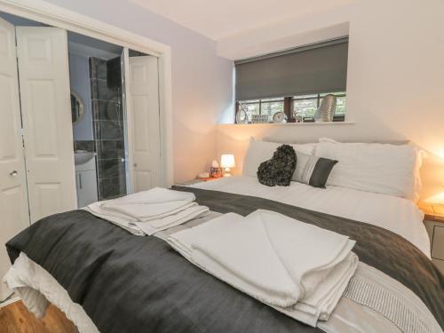 a bedroom with a large bed with white sheets at Glebe Hall Apartment in Marske-by-the-Sea