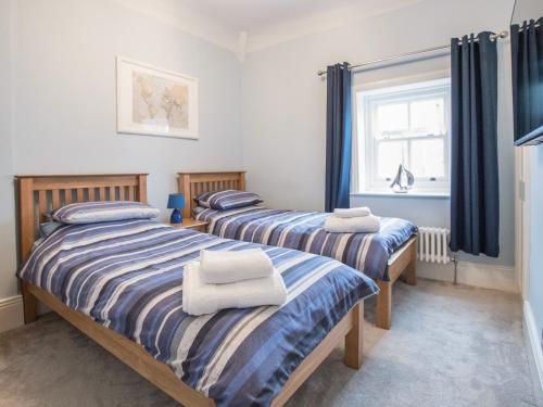 two twin beds in a room with a window at The Tynemouth Cottage in Tynemouth